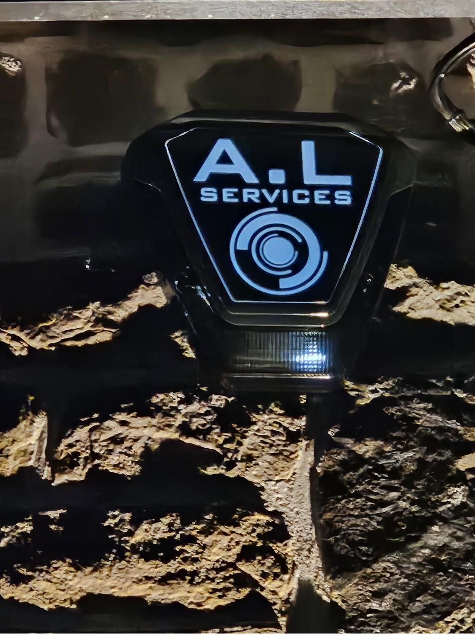 Illuminated A.L Services bell box at night