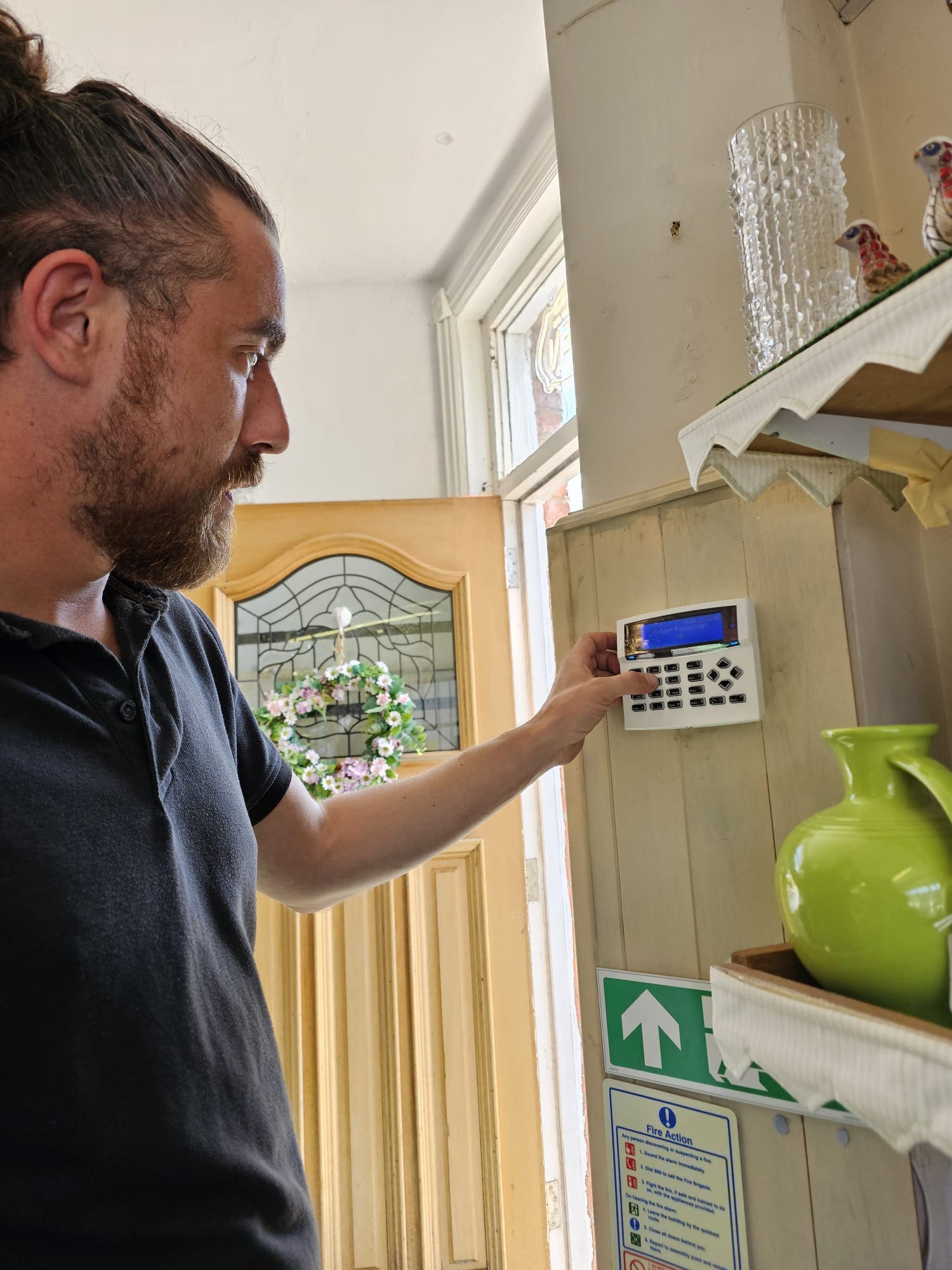 Andy programming an alarm keypad by the front door of a Lancashire shop