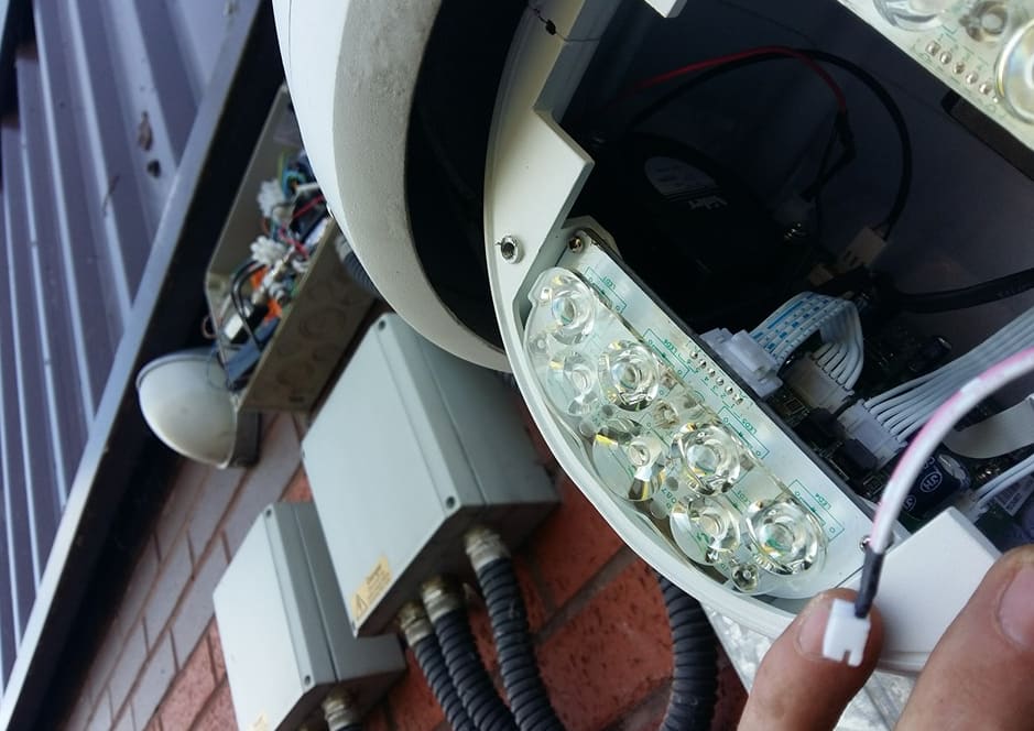 PTZ camera opened up on the wall for maintenance, IR array and wiring visible